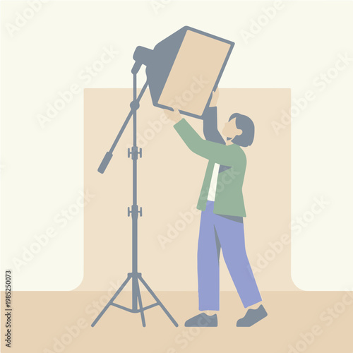Photographer Adjusting Studio Lighting Equipment for a Shoot.