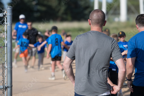 Kids enjoy a fun baseball practice with their coaches at a local park on a sunny afternoon in summer