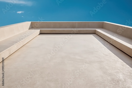 Roof terrace features a minimalist concrete structure set against a vibrant blue sky with no people present in the scene.