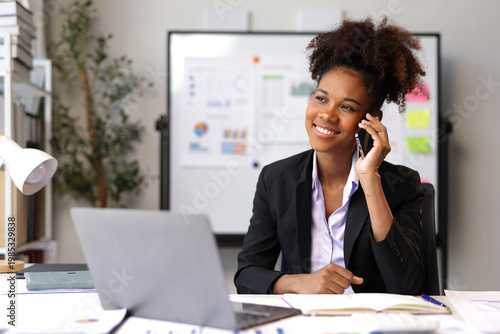 Smiling businesswoman talking on phone in office.