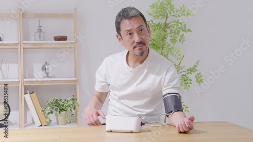 血圧計で血圧を測定する中高年男性