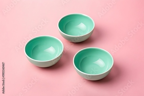 Three Mint Green Ceramic Bowls Arranged on a Pink Background Keywords: bowl, ceramic, dishware, kitchenware