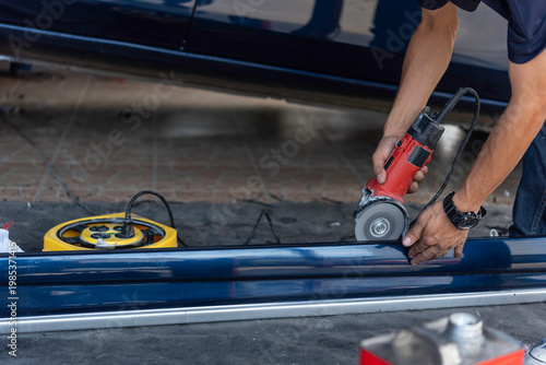 Photography Technician polishing car body with electric angle grinder showing surface refine