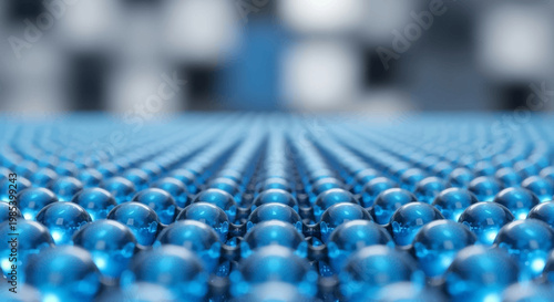 Close-up view of numerous blue spheres arranged in a precise grid pattern, suggesting advanced technology or molecular structure.