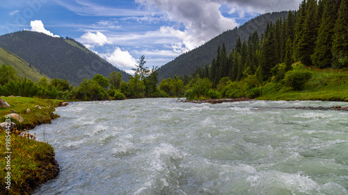 Scenic river flowing through mountains and forest in Kyrgyzstan