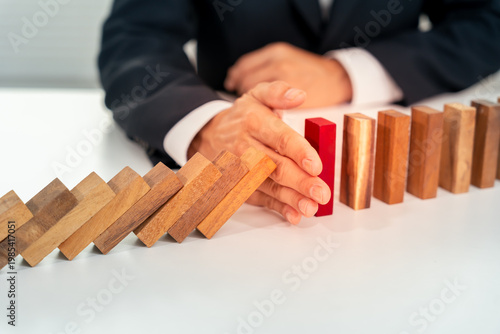 insurance with hands protect domino. Businessman hands stop dominoes falling in business crisis. business risk control and planning and strategies to run prevent insurance businesses.