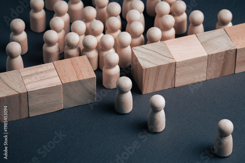 Quadro su tela Wooden peg figures face a solid wall made of wooden blocks, representing structural capacity limits, systemic constraints, and organizational barriers in business or institutional environments