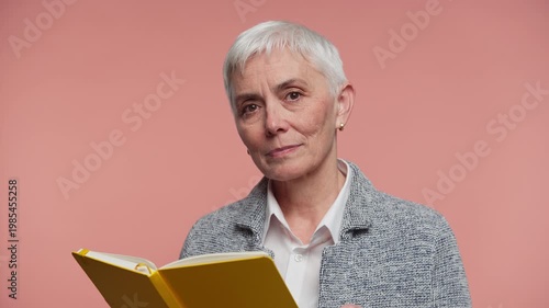 Senior woman holding yellow book portrait