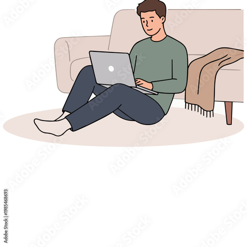 A man sits on the floor with a laptop on his lap in a living room