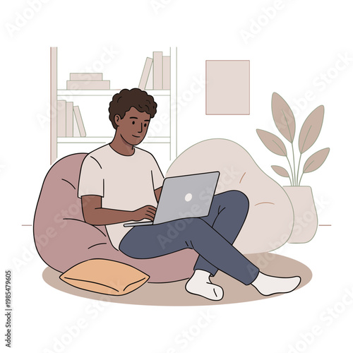 Man sitting on bean bag chair working on laptop at home