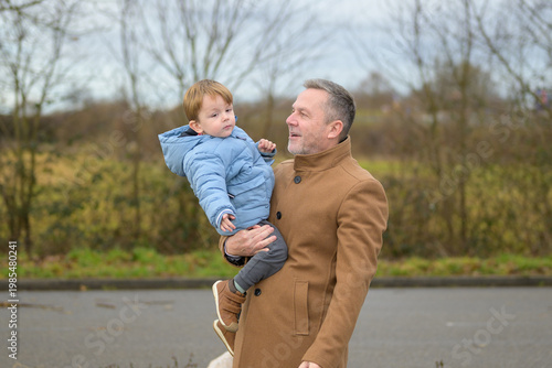 Grandfather Holding Toddler Outdoors Winter