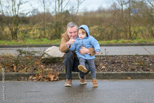 Grandfather Pointing While Holding Grandchild