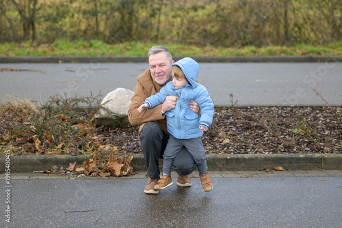 Grandfather Holding Toddler Outside Winter