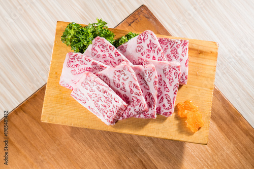 Marbled raw beef slices on board