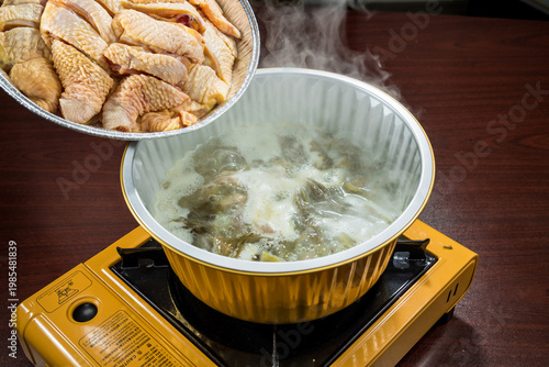 Simmering chicken broth on portable stove