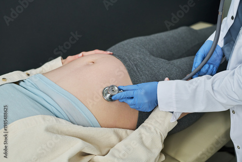 Tableau sur toile Close up of pregnant woman receiving prenatal examination while doctor monitoring fetal health with stethoscope