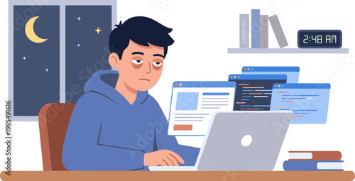 A man sits at a desk working on a laptop at night