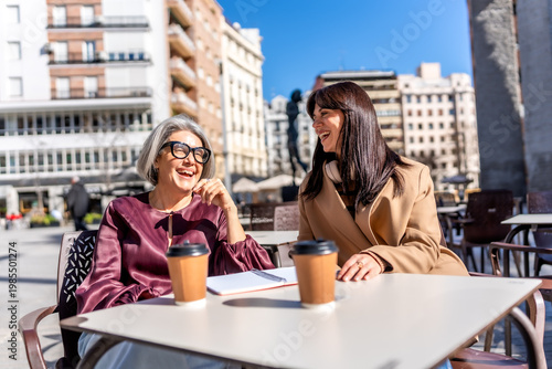 Women enjoying coffee and conversation at outdoor cafe