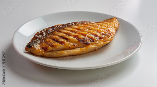白い皿に盛られた香ばしく焼いた魚の切り身