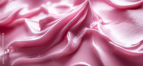 Close-up texture of pink cosmetic cream or body lotion. Smooth, wavy swirl of moisturizing product. Beauty and skincare background for advertising, professional cosmetic treatment concept
