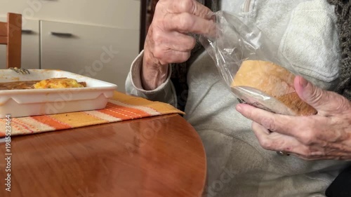 Senior woman struggling to unpack the bread packing.