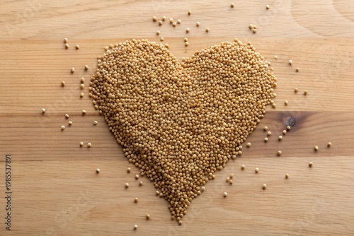Amaranth Month A heart shape made of small grains on a wooden surface