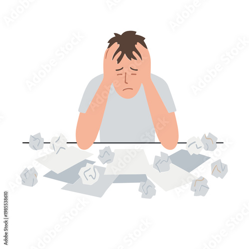 A frustrated man sits at a desk with crumpled papers and stressed expression