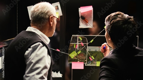фотографія Police agents review board with clues to piece all puzzle together and build culprit profile, solve crime