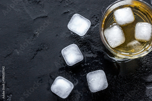 glass of scotch on dark background top view