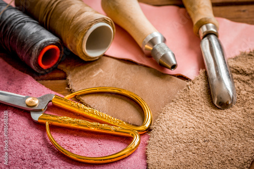 leather craft instruments on wooden background close up