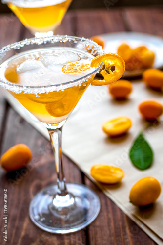 cocktail with kumquat on wooden background