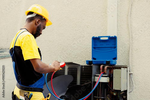 Fotografía Proficient african american worker doing routine condenser maintenance, assembling manifold indicators before starting work