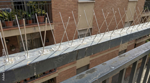 Bird spikes installed on balcony railing to deter birds  