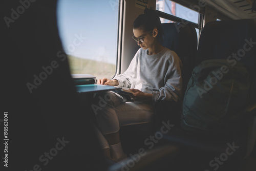 Woman reading book during train travel