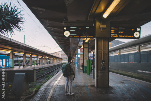 Solo traveler with backpack at railway station