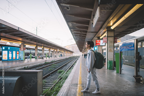 Woman with backpack waiting at railway platform