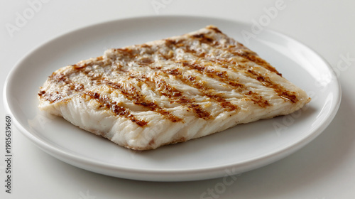 白い皿に盛られた焼き目が美しいふっくらとした白身魚のグリル
