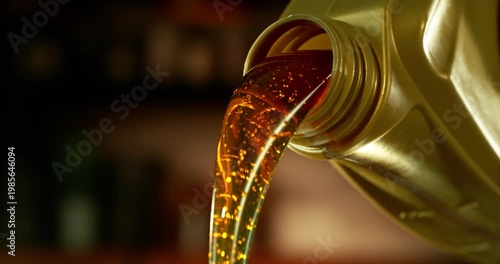 Super slow motion (1000 fps) close-up of motor oil pouring from a container. Smooth golden liquid flow with bubbles and reflections, isolated cinematic shot with shallow depth of field.