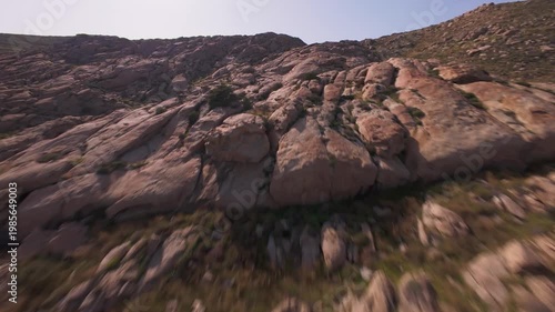 A cinematic FPV drone flight over unique smooth rock formations at Kolymbithres Beach on Paros island, Greece. Natural sculpted stones create an unusual landscape, perfect for travel, nature 