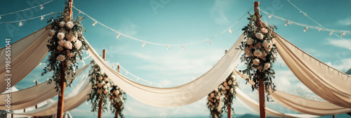 A wedding tent stands near the lake, decorated with flowers. Guests gather for a celebration in the afternoon sun. Lush greenery surrounds the area creating a festive atmosphere