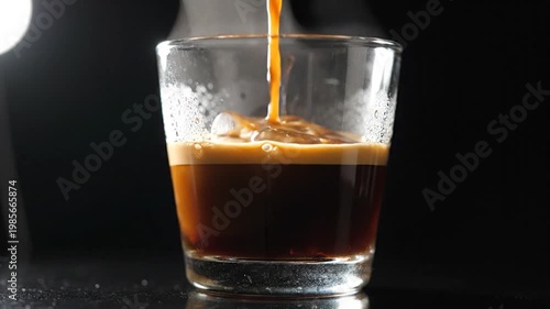 Espresso Shot Poured Over Ice in a Glass on a Dark Background.