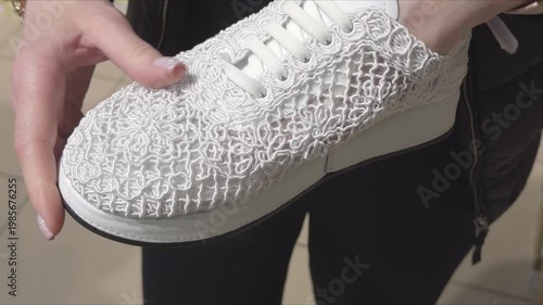 White sneaker with voluminous textured upper in a shopper's hands