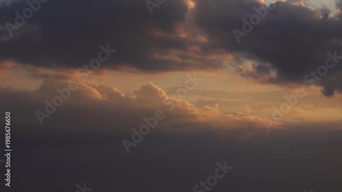 Dark Evening Rain Clouds and Cumulus Strips at Sunset.