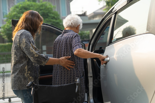 Caregiver help Asian elderly woman disability patient get in her car.