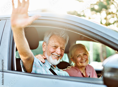 Happy senior couple going on a trip in their car