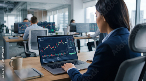 Business professional analyzing trading chart on laptop in modern office