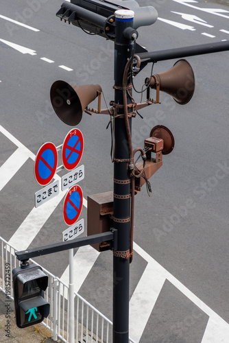 交差点のポールに設置されたスピーカーと歩行者用信号機・道路標識