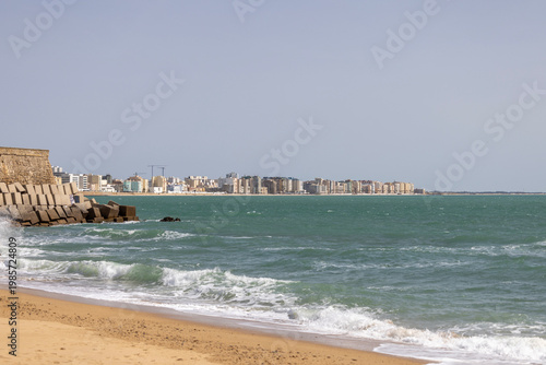 View from La Caleta Beach to stone breakwater and panorama of city on Atlantic coast, Cadiz, Spain, Andalusia