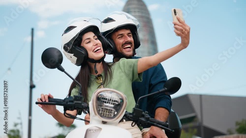 Video of cute couple taking selfies with smartphone while stopped on a motorbike in the city