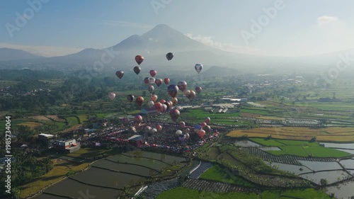 Hot air balloons float over a quaint village by mount sindoro in indonesia. Ideal for travel blogs, tourism promotions, and adventurethemed content.